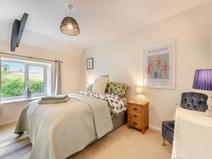 a bedroom with a bed and a chair at Church View Cottage - Uk45697 in Pickering