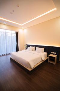 a bedroom with a large white bed with a window at Grand Permata Hijau Hotel in Sukabumi