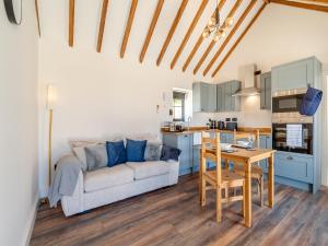 een woonkamer met een bank en een tafel bij Fountain Front Barn - Uk45937 in Corley