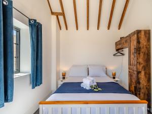 een slaapkamer met een bed met blauwe gordijnen bij Fountain Front Barn - Uk45937 in Corley