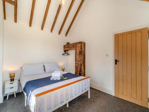 een slaapkamer met een bed en een houten deur bij Fountain Front Barn - Uk45937 in Corley +11 foto's
