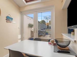 Zimmer mit einem Tisch und Stühlen sowie einer Glasschiebetür in der Unterkunft Y Ty Glas - Cottage in New Quay