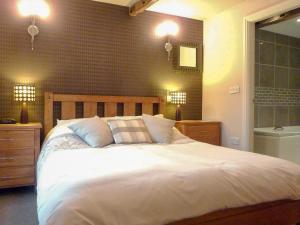 a bedroom with a large white bed and two lights at High White Stones in Ambleside +4 photos