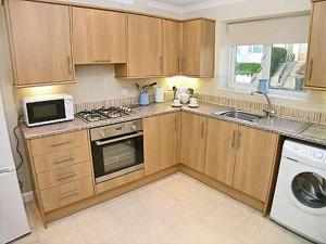 a kitchen with a microwave and a stove top oven at Breedsmoor Cottage in Ore