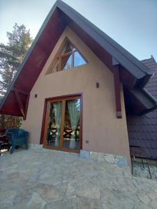 ein Haus mit einem großen Fenster und einer Terrasse in der Unterkunft Mountain House Tadić 3 in Bajina Bašta