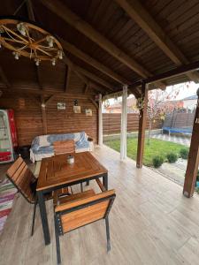 a wooden patio with a table and a bed at Casa Sofia in Livezeni +28 photos