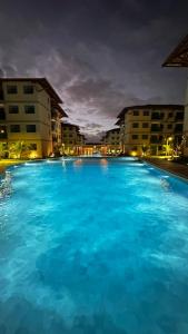 ein großer Pool mit blauem Wasser in der Nacht in der Unterkunft Villa sol e mar, seu refúgio em Muro Alto in Ipojuca