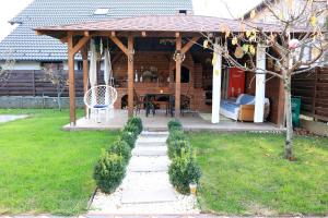 a wooden gazebo with a table and a chair at Casa Sofia in Livezeni