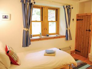 ein Schlafzimmer mit einem Bett und einem Fenster in der Unterkunft Shore Cottage - S4600 in Tarbert