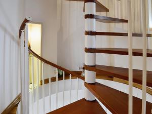 una escalera de caracol en una casa con suelo de madera en The Windmill, en Coedana 16 fotos más