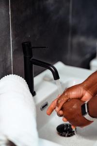 a person is drinking water from a faucet at Ahomé Guest house & Lounge in Lomé +31 photos