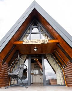 a house with a large window and a chair at Čarobna jutra Zlatara 2 in Radijevići