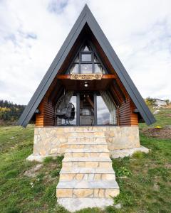 a small house with a black roof and a stone staircase at Čarobna jutra Zlatara 2 in Radijevići