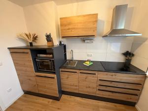 a kitchen with a sink and a stove top oven at Wohlfühlapartment, Parkplatz, Boxspringbetten, Massagesessel, Nespresso, 1Gbit LAN & WIFI, Innenstadt in Wolfsburg
