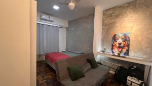 una sala de estar con sofá y una pintura de un perro en Excelente perto do Aeroporto e Metro e 3 km das Praias, en Río de Janeiro