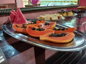 a glass plate with slices of fruit on a table at Pousada Colonial in Macaé