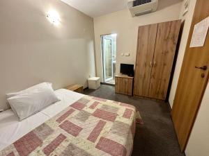 ein Schlafzimmer mit einem Bett und einem Fernseher darin in der Unterkunft Julia rooms in Sofia