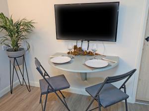 DishforthにあるRaygill Shepherds Hutのテーブル(椅子2脚付)、薄型テレビが備わります。