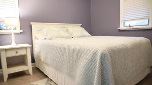 una camera da letto con un letto con un copriletto bianco e un tavolo di Bay Escape a North Cape May