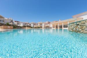 a swimming pool in a villa with blue water at NAU Salema Beach Village in Salema
