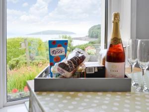 a gift box with a bottle of champagne and a window at Balcary Mews Cottage in Auchencairn