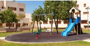 a playground in a park with two swings at Relax & Play Panoramic Golf Vinaroz, Sant Jordi Apartment in Vinarós