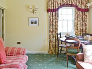 a living room with a table and a window at Laundry Cottage in Uldale