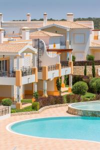 a villa with a swimming pool and a resort at NAU Salema Beach Village in Salema