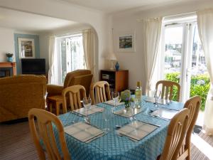 a dining room with a blue table and chairs at Spinnakers in Falmouth