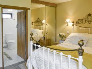 ein Schlafzimmer mit einem Bett und ein Badezimmer in der Unterkunft Riverside Cottage in Costessey + 4 Fotos