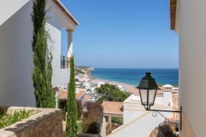 a view of the ocean from the balcony of a house at NAU Salema Beach Village in Salema