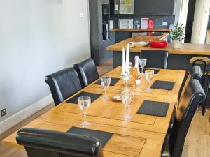 una larga mesa de madera con copas de vino. en Winthorp, en Ivychurch