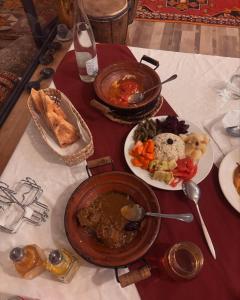 ein Tisch mit Tellern voller Essen auf einem Tisch in der Unterkunft Dar Nomad Tagounite in Zagora