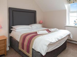 a bedroom with a large bed with two towels on it at Captain's Lodge - Uk6732 in Lydstep +12 photos