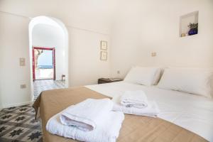 a bedroom with a white bed with towels on it at Sunhaus in Perissa