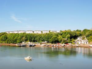 un barco en un cuerpo de agua con una playa en Woodpecker-Qc1186, en Milford Haven