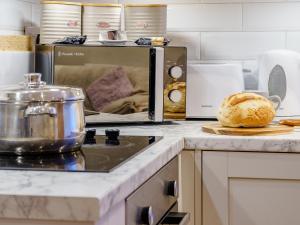a kitchen counter with a microwave and a loaf of bread at The Cottage-Uk32854 in Alltwen +19 photos