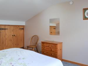 a bedroom with a bed and a dresser and a chair at Lakeland View in Scotforth +7 photos