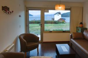 Departamento del Lago II في سان كارلوس دي باريلوتشي: غرفة معيشة بها أريكة وكرسي ونافذة