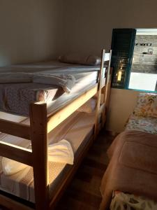 zwei Etagenbetten in einem Zimmer mit Fenster in der Unterkunft Casa de temporada - PISCINA, FOGÃO A LENHA E CHURRASQUEIRA in Lindóia