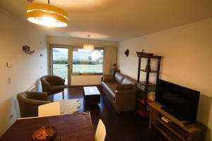 Departamento del Lago II في سان كارلوس دي باريلوتشي: غرفة معيشة مع أريكة وتلفزيون