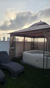 un gazebo avec un lit et une chaise sur un balcon dans l'établissement Sunset Home, à Netanya 7 autres photos