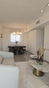 un salon avec un canapé blanc et une table dans l'établissement Sunset Home, à Netanya