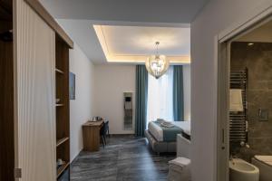 una camera da letto con un letto e un bagno con un lavandino di Mare Luxury a Napoli Altre 66 foto