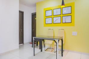 浦那Collection O Baner Hillview Pune Formerly Siri Lodge的餐厅里有一张桌子和几把椅子