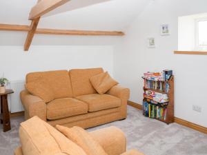 a living room with a couch and a book shelf at Criffel Cottage in Ruthwell