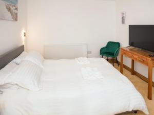 a bedroom with a bed and a desk and a television at Criffel Cottage in Ruthwell +15 photos