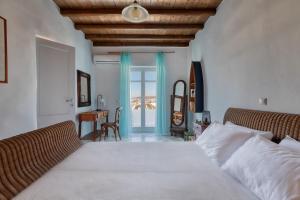 a bedroom with a bed and a desk and a window at Villa Zanetti Mykonos in Agios Ioannis Mykonos +27 photos