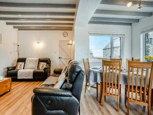 a living room with a table and chairs and a dining room at Stable Cottage - Uk10694 in Amroth