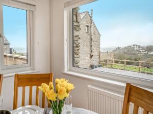 a dining room with a table and a window at Stable Cottage - Uk10694 in Amroth